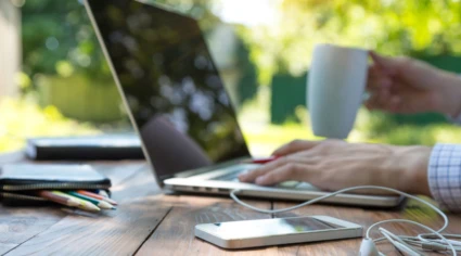 Man jobbar vid en laptop ute i naturen