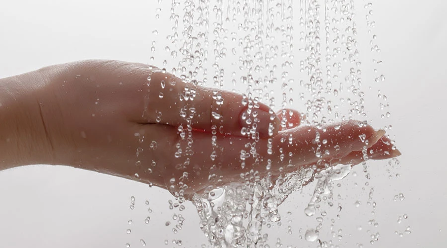 En hand i närbild där det rinner vatten i