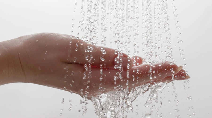 Vatten rinner ner i en hand i närbild