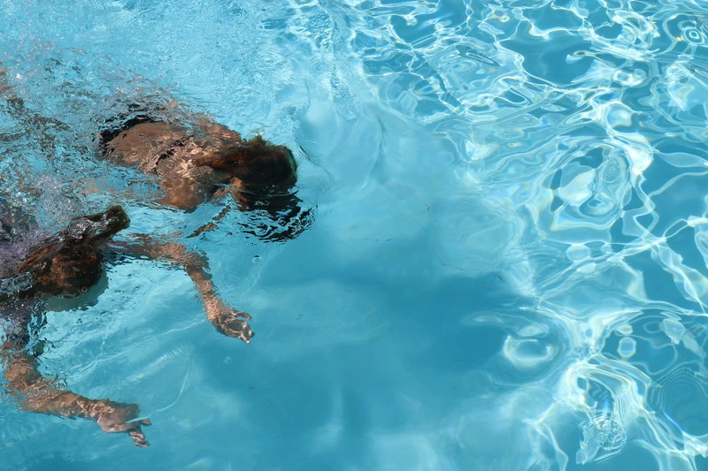 Två barn som simmar i bassängen på Örmobadet