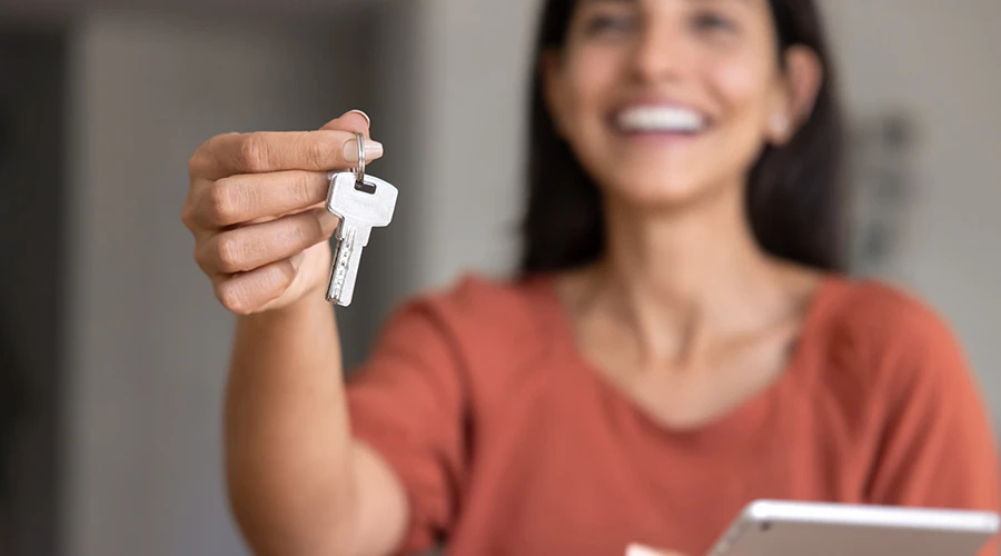 En kvinna håller upp en nyckel med handen