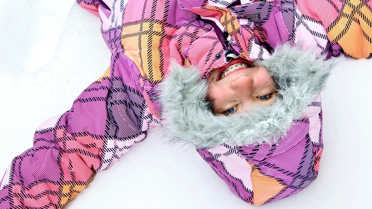 Barn gör snöängel i snö