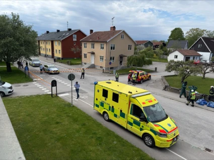 Ambulans, brandbil och polisbilar på avspärrad gata.